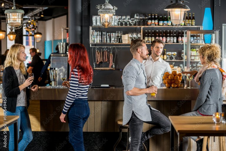 Friends Talking While Having Their Drinks In Bar