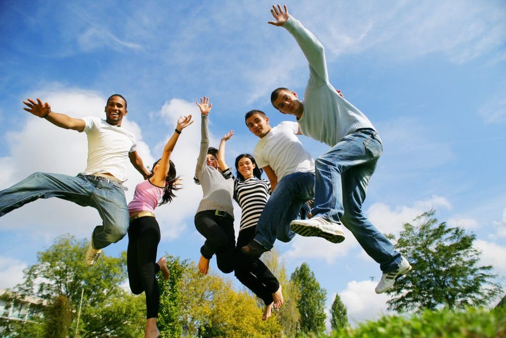 hommes et femmes souriants sautant en l'air