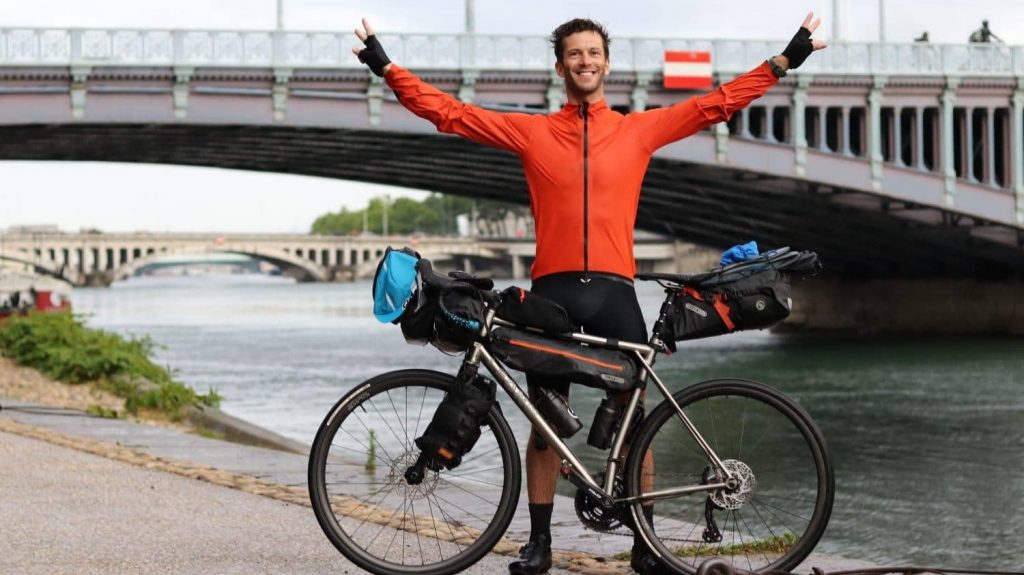 Charles Steinmyller devant son vélo à Lyon au bord du Rhône