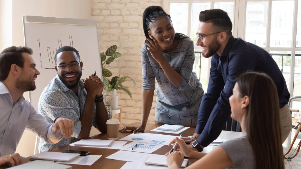 Des collègues sont réunis autour d'une table et sont souriants