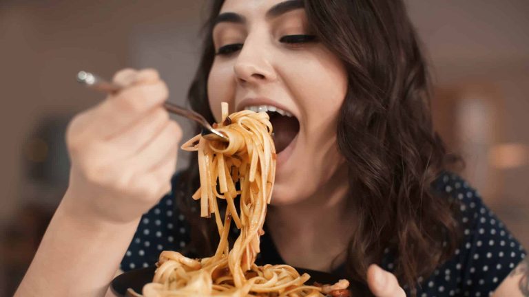 Femme qui mange des pâtes