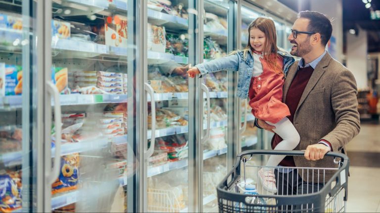 Père et fille devant congélateur supermarché