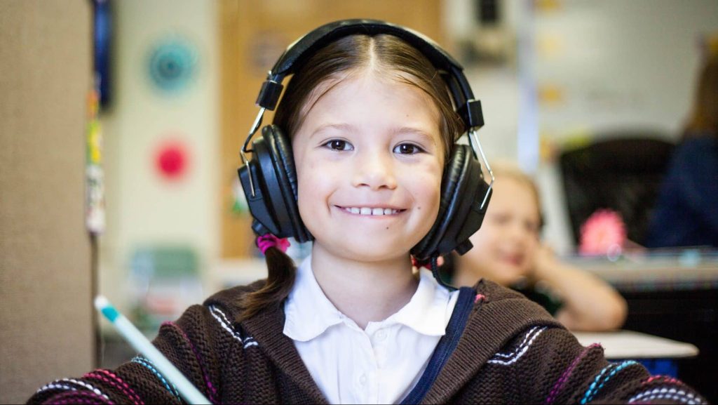 Une enfant porte une casque pour écouter la musique.