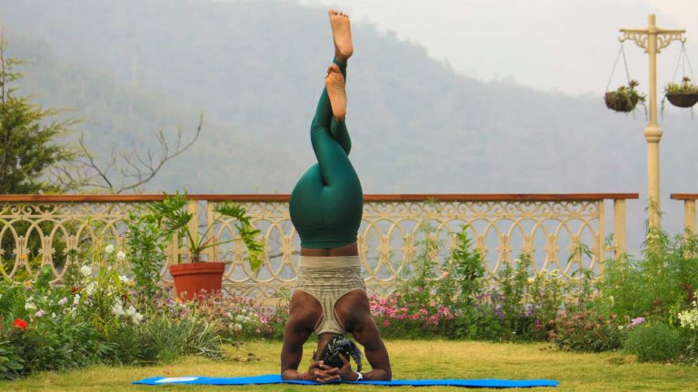 Une dame effectue une posture d'inversion de yoga