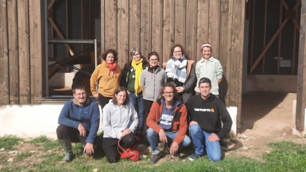 7 femmes et 3 hommes posent et sourient devant un ancien séchoir à tabac en bois