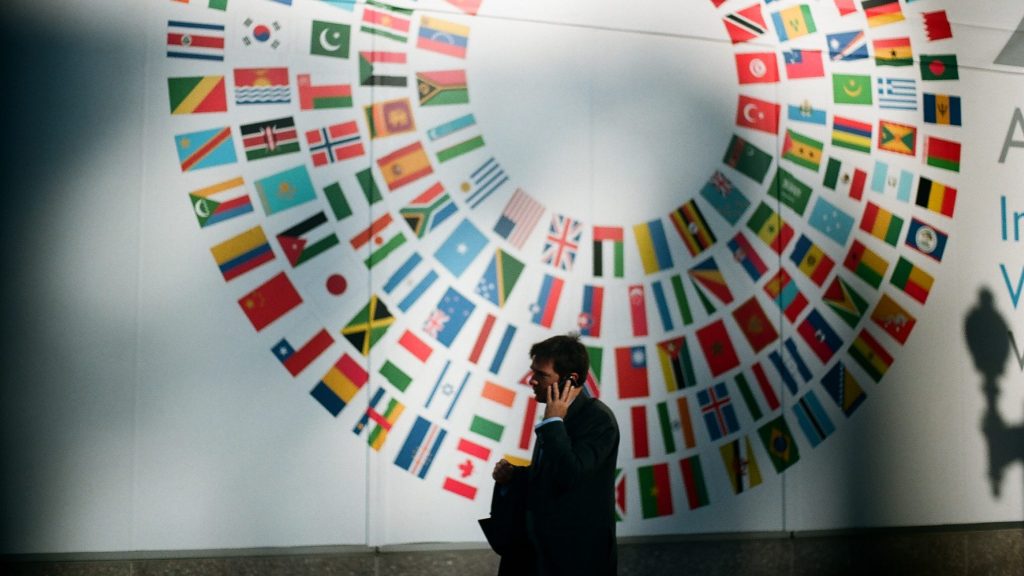 Une femme devant une fresque de drapeaux