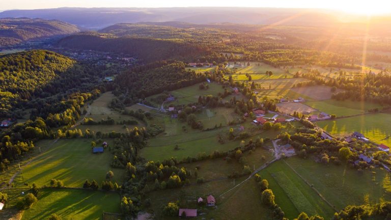 Vue du ciel, des prés entourées de haies avec quelques maisons et fermes