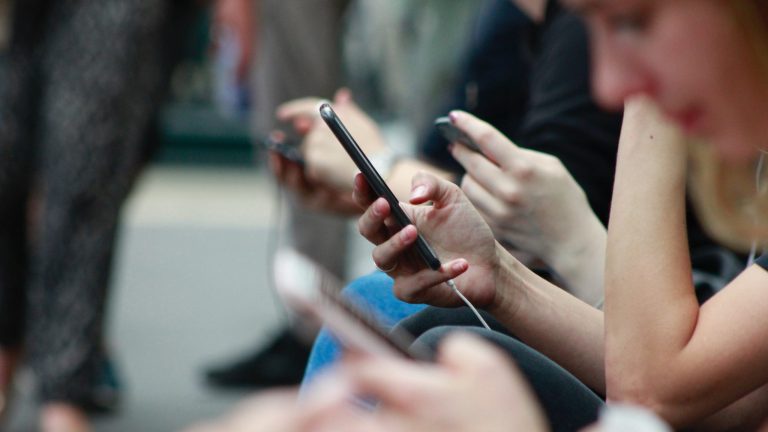 Des jeunes qui consultent leurs smartphones