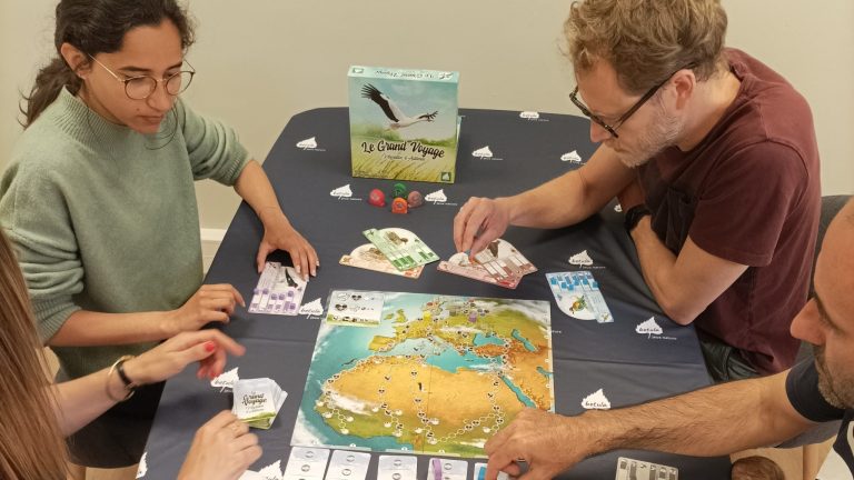 Des personnes joue au jeu de société le Grand Voyage