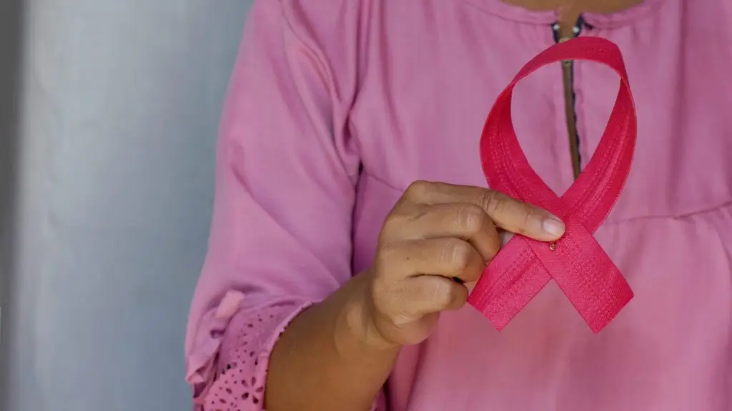 Une femme à un ruban rose dans les mains