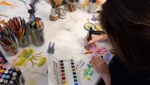 Une femme dessine à l'aquarelle lors d'un atelier dessin de Bénédicte Dufour