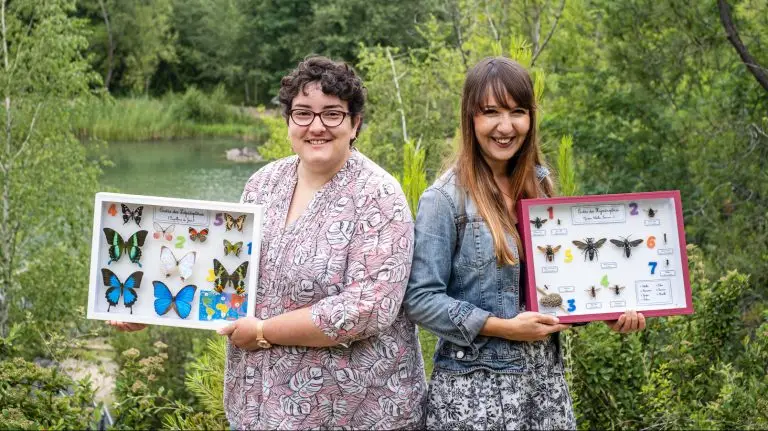 Diane Bigot et Cristela Sanchez Oms fondatrice de Fourmidables. Elles montrent chacune une collection de papillons colorés. Elles sont dans la nature