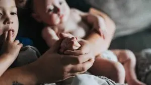 person holding baby on gray textile