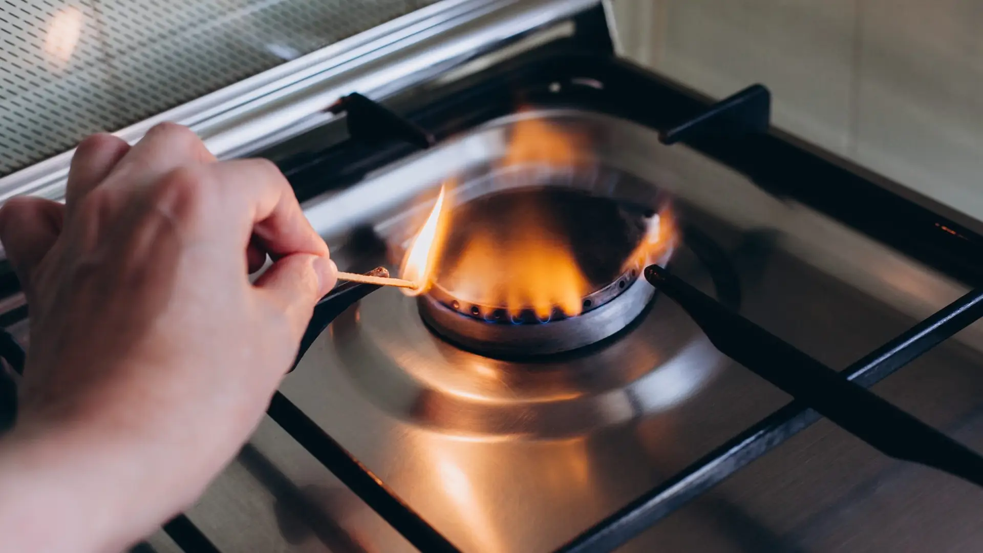 Une personne allume un feu de gaz