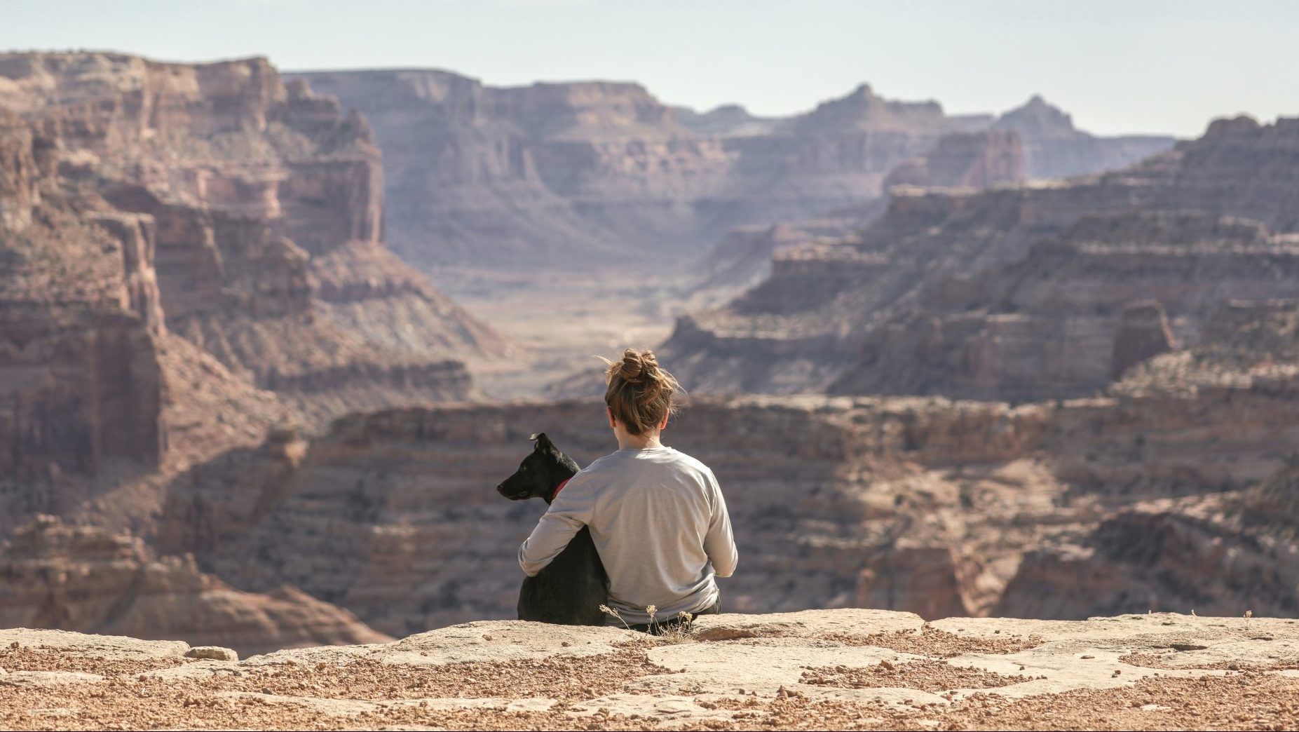 Femme et chien devant un Canyon.