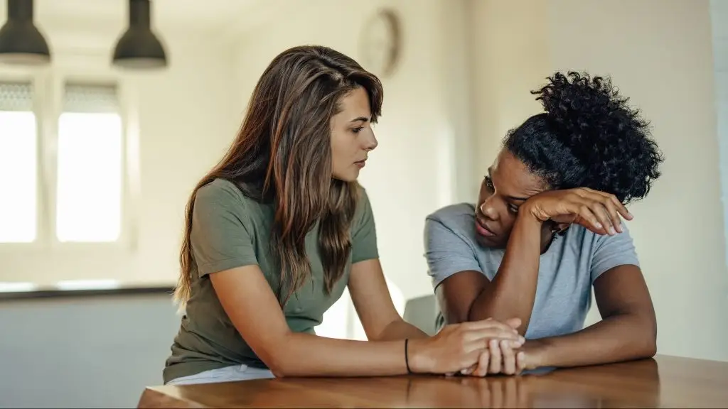 Une femme écoute attention une autre femme et lui tient la main