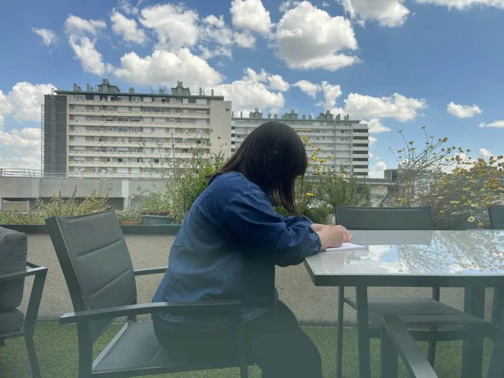 Jeanne travaille sur la table de la terrasse de la radio