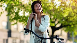 Une femme à vélo qui met son casque