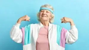 Une femme senior montre ses muscles en souriant