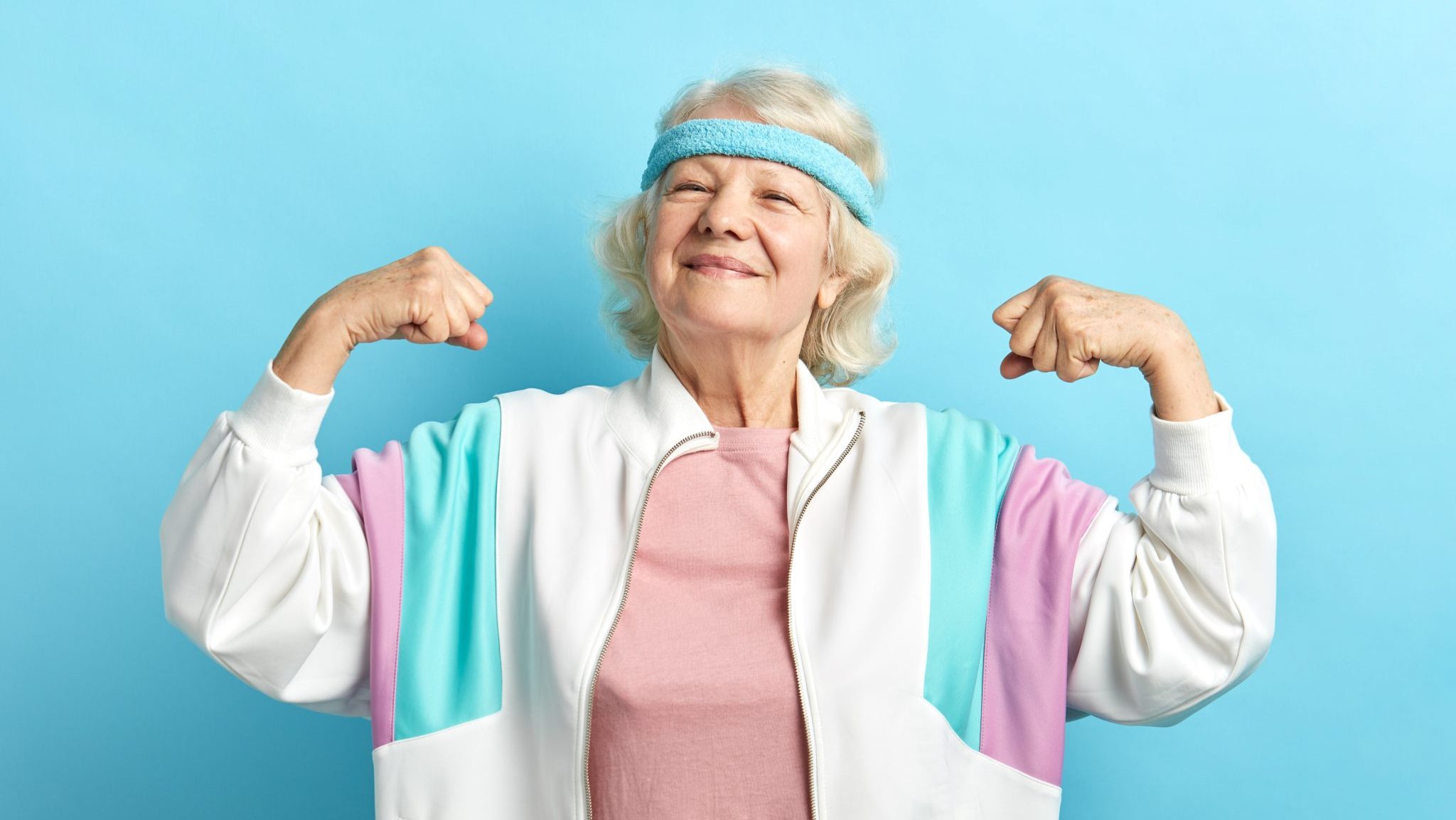 Une femme senior montre ses muscles en souriant