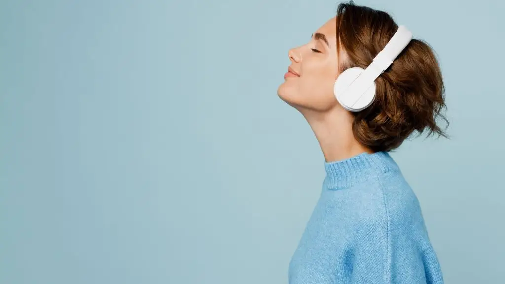 Une femme avec un casque de musique sur les oreilles.