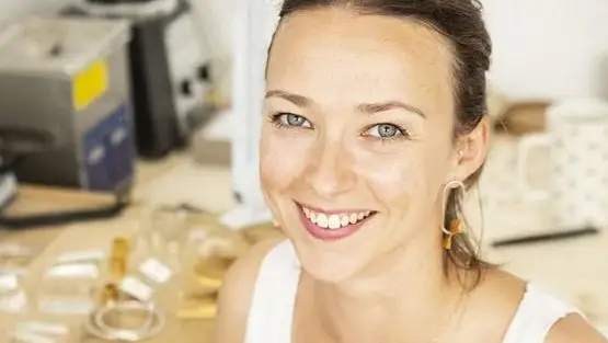 Femme joaillère devant table de création de bijoux