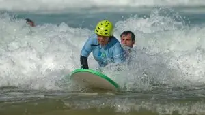 Une personne avec une déficience visuelle découvre le surf avec l'association See surf