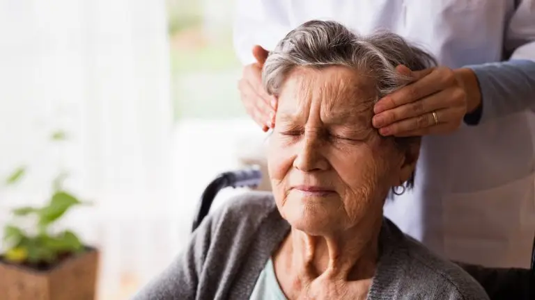 Une personne âgées se fait masser la tête