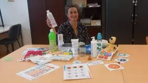 Julie Cardinaud sage-femme au CHU de Bordeaux, est assise à une table avec différents produits qu'elle présente lors de ces ateliers nesting santé et environnement.