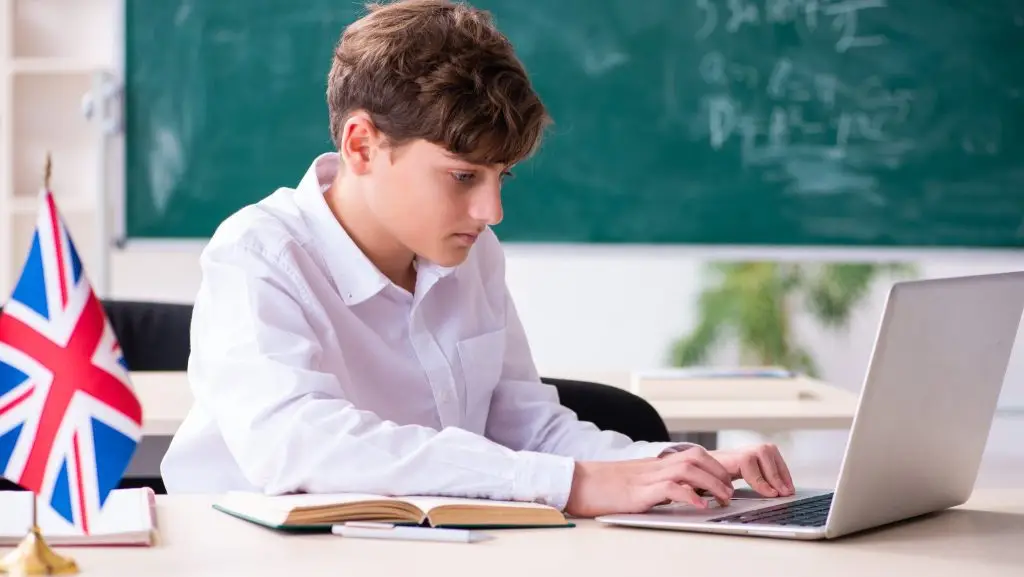 Un garçon apprenant l'anglais en classe avec son ordinateur