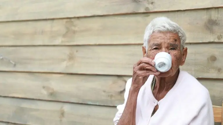 Une personne âgée boit un café