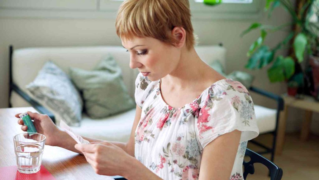 Une femme lit une notice de médicament