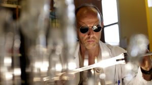 thierry pain souffleur de verre au cnrs travaille une pièce avec lunettes noires sur la tête