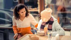 Une femme qui accompagne une sans abri au restaurant