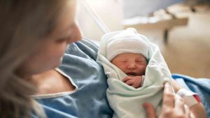 Une mère tient son bébé à la maternité.